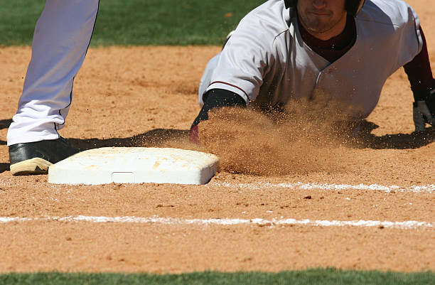 Baseball player sliding into base stock photo