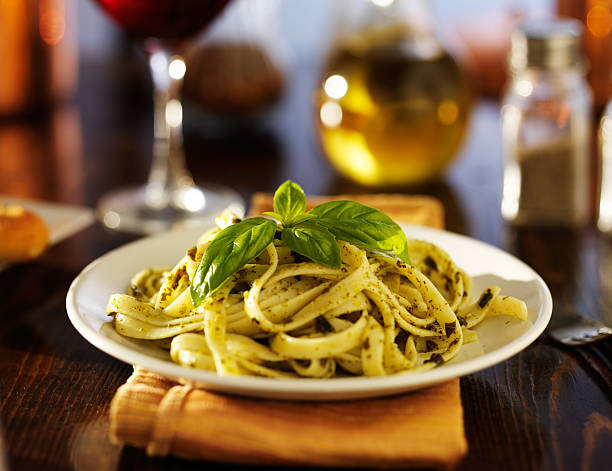 basil pesto sauce on fettuccine pasta stock photo