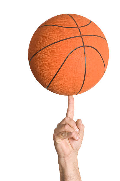 Basket Ball Spinning A close up of a basket ball spinning on a finger, isolated on white. spinning stock pictures, royalty-free photos & images