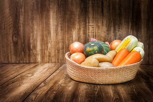 Basket with harvest of vegetables and fruits for on the wooden background