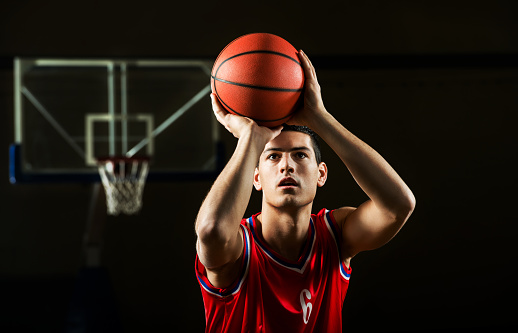 Front view of basketball player shooting at the hoop.