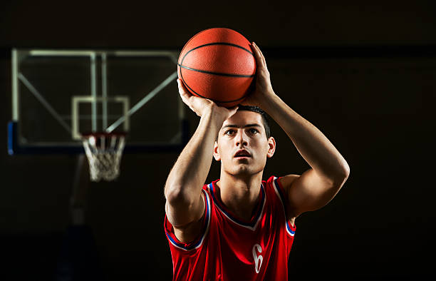 Basketball player. Front view of basketball player shooting at the hoop. hitting stock pictures, royalty-free photos & images