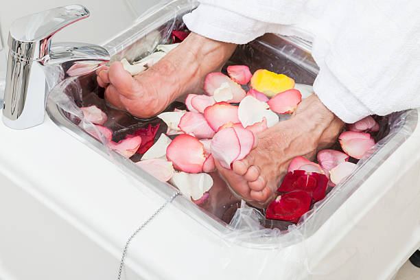 bath with rose leaf bath with rose leaf in pedicure man pedicure stock pictures, royalty-free photos & images