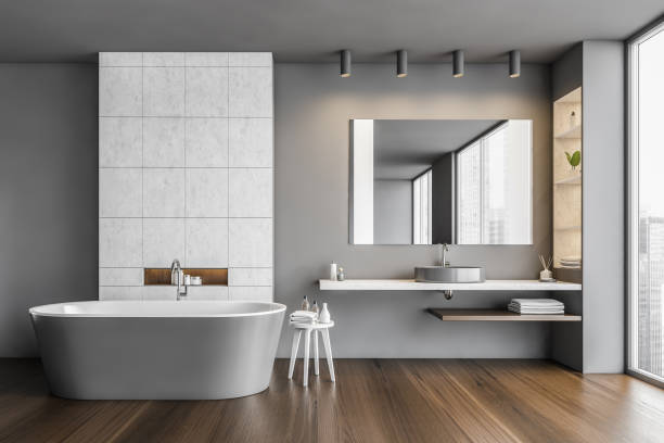 Bathroom in grey and wooden design with row of bathtub, sink and mirror stock photo