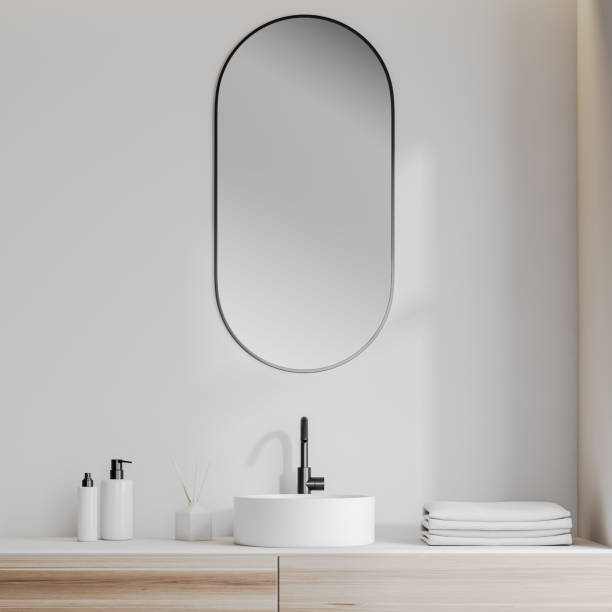 Bathroom sink in white room Close up of white bathroom sink standing on wooden counter with oblong mirror above it in room with white walls. 3d rendering vanity stock pictures, royalty-free photos & images