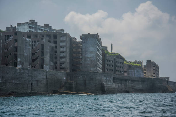 Battleship Island (Gunkanjima, Hashima, Gunkanjima, Gunkanjima, Gunkanjima) Hashima Island (端島 or simply Hashima — -shima is a Japanese suffix for island), commonly called Gunkanjima (軍艦島; meaning Battleship Island), is an abandoned island lying about 15 kilometers (9 miles) from the city of Nagasaki, in southern Japan. It is one of 505 uninhabited islands in Nagasaki Prefecture. The island's most notable features are its abandoned concrete buildings, undisturbed except by nature, and the surrounding sea wall. While the island is a symbol of the rapid industrialization of Japan, it is also a reminder of its dark history as a site of forced labor prior to and during the Second World War. mitsukejima island stock pictures, royalty-free photos & images