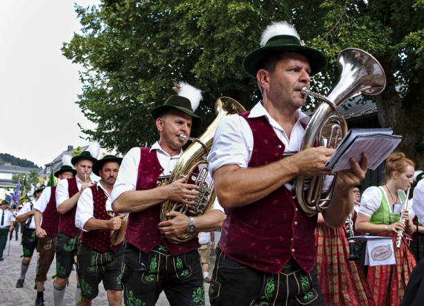 bayerische blaskapelle in traditioneller kleidung spielt blechblasinstrumente bei einer parade - oktoberfest stock-fotos und bilder