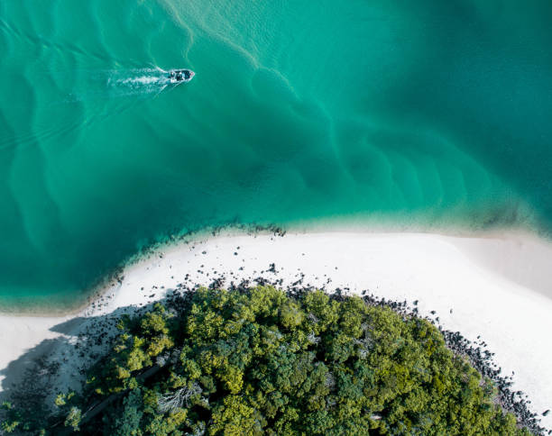 Beach aerial summer with boat and blue tropical water. Beautiful gold coast hot drone shot with boat and sand drift. Beach aerial with boat and blue tropical water. Drone shot tropical scene with nice blue water, sand drift and warm summer vibes headland stock pictures, royalty-free photos & images