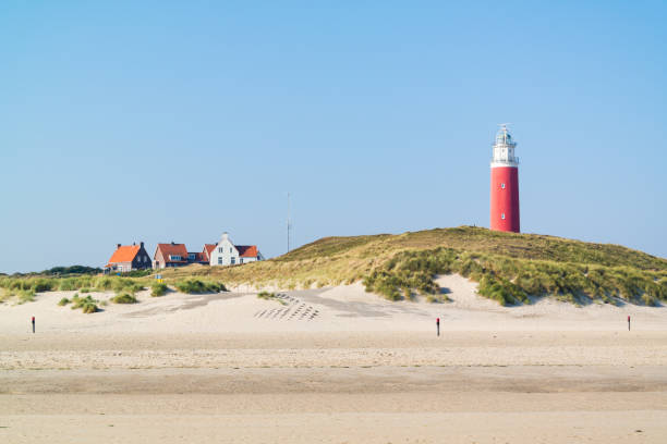 Beach and lighthouse De Cocksdorp, Texel, Netherlands stock photo