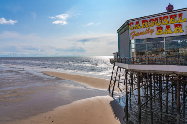 Beach and Pier view in Blackpool View of the North Pier and Blackpool beach with a low tide in the summer time on August 12, 2019 in Blackpool north pier stock pictures, royalty-free photos & images
