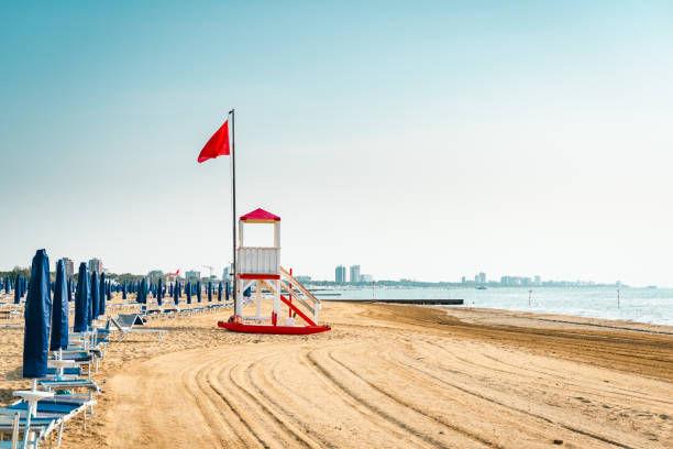 Beach at the Adriatic sea in Italy, Europe during summer. Beach at the Adriatic sea coastline in Italy, Europe during summer. Traditional hut for the beach lifeguard and a red flag. adriatic sea stock pictures, royalty-free photos & images