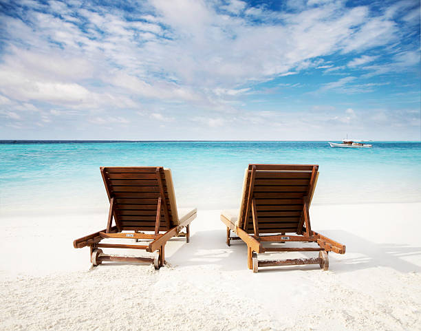 Beach chairs on waters edge stock photo
