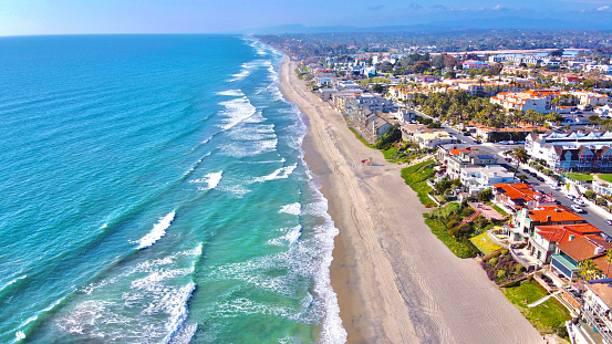Beach shot from drone showing coast of California and homes along the sand