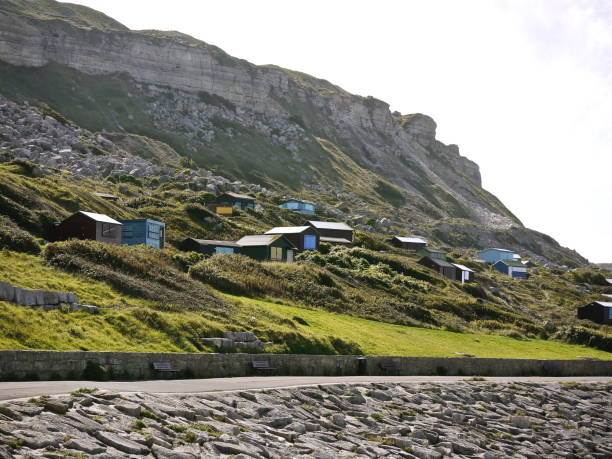 Beach huts at Chesil Cove Portland Dorset part of the World Heritage Jurassic Coastline England beach huts at Chesil Cove Portland Dorset England part of the World Heritage Jurassic coastline. taken from public footpath. jurassic world stock pictures, royalty-free photos & images