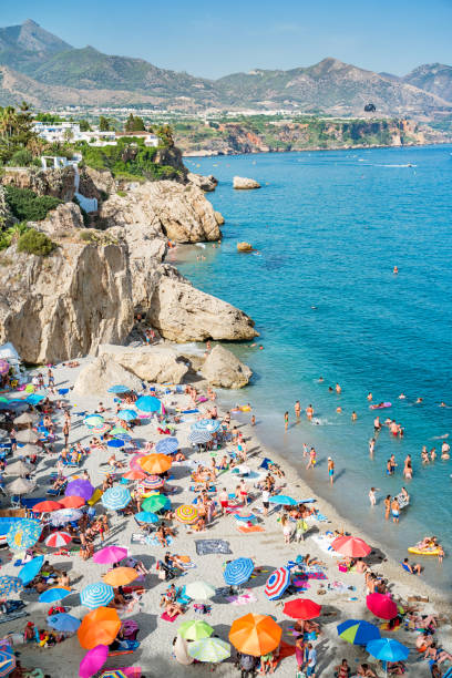 Beach in Nerja Costa del Sol Andalusia Spain Stock photograph of beach with crowd of people and the Mediterranean Sea in Nerja, Costa del Sol, Andalusia, Spain on a sunny day. nerja stock pictures, royalty-free photos & images