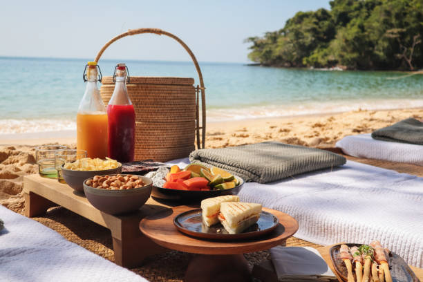 Beach Picnic by the sea with snacks and fruit and juice drinks stock photo