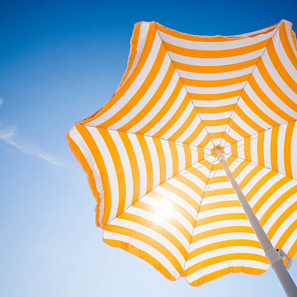 parasol de plage contre le ciel bleu du matin - parasol photos et images de collection