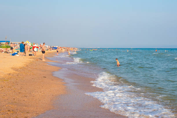 Beach vacation on the seashore. Tourists swim in the sea and sunbathe on the sand stock photo