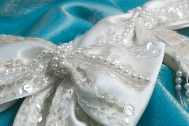 Beaded bow wedding trim on turquoise fabric stock photo