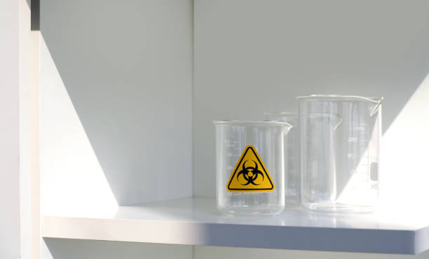 Beaker with biohazard symbol on a white shelf in laboratory. stock photo