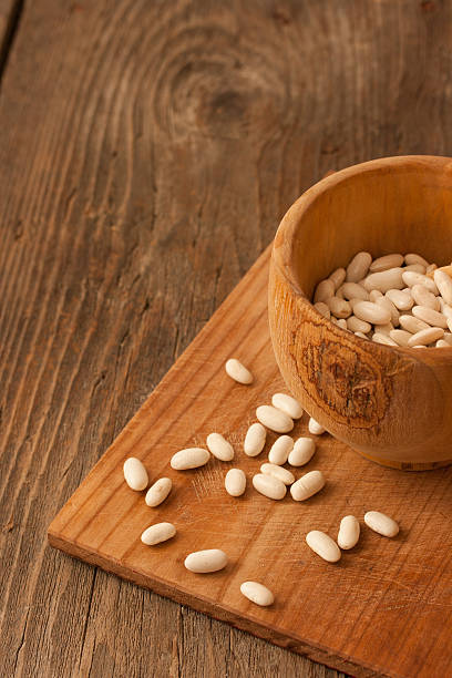 Beans in a wood pot on natural textured wood background stock photo