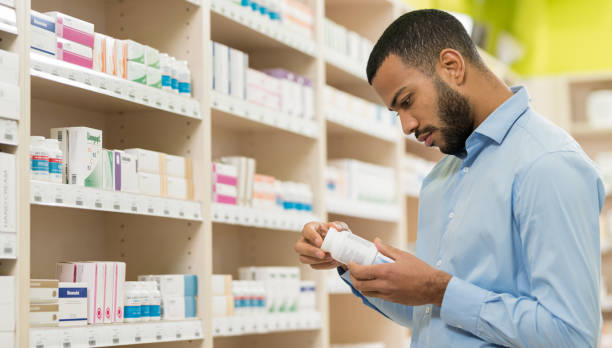 Beard Man Choosing Supplement In Drugstore stock photo
