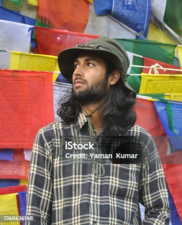 istock A bearded and long haired male tourist looking sideways while standing against tibetan prayer flags 1360636148