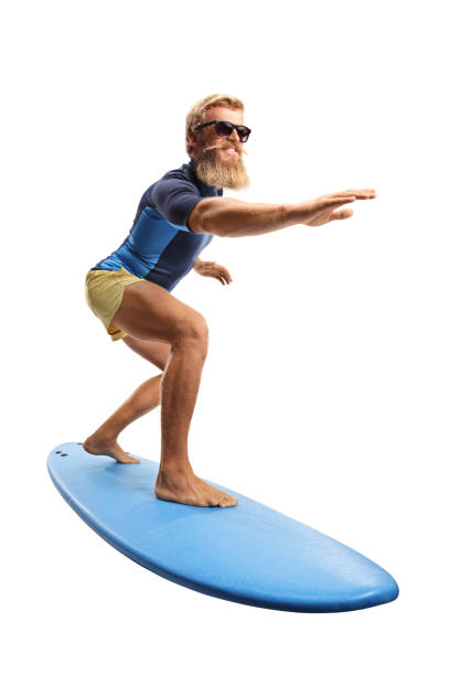 Bearded guy with sunglasses riding a surfboard stock photo