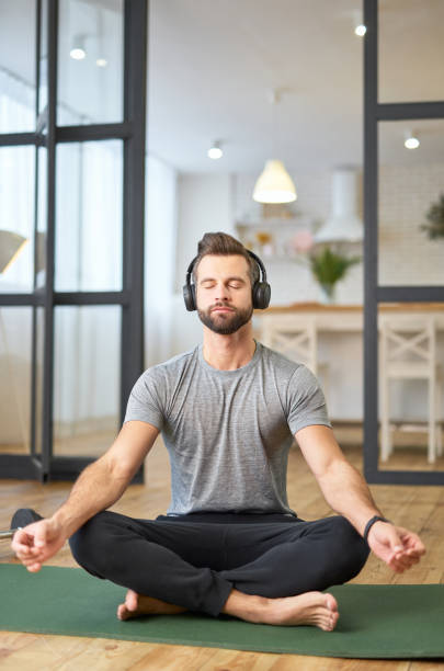 Bearded young man listening to music and meditating stock photo
