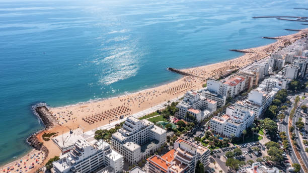 Beautiful aerial cityscapes of the tourist Portuguese city of Quarteira. On the seashore during the beach season with tourists who are sunbathing. stock photo