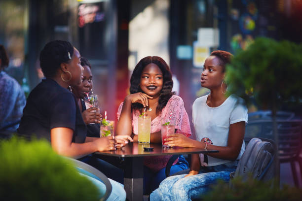 beautiful african american girls talking, sitting in summer cafe stock photo