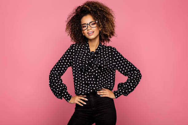 Beautiful african american model Portrait of beautiful smiling black woman wear glasses and black shirt with white peas hand on hip stock pictures, royalty-free photos & images