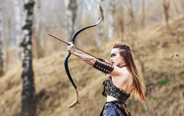 Beautiful amazon woman posing with bow stock photo