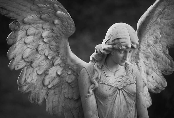 Beautiful Angel Beautiful Angel Statue stands watch over graves in a cemetery in the northeastern U.S. (Scanned black and white negative with noticeable grain). angel stock pictures, royalty-free photos & images
