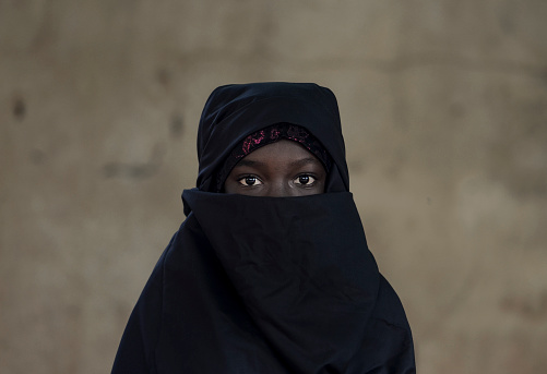 Little African girl posing outdoors veiled by a Niqab (typical traditional muslim clothing).