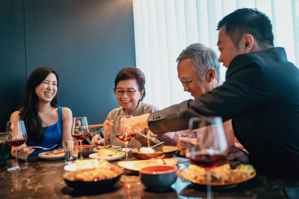 Beautiful asian family enjoying a meal in a restaurant stock photo