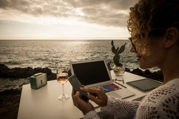 beautiful assistant professional lady at work in alternative freedom concept office in front of the ocean. enjoy a different lifestyle and work with social media like digital nomad - cargo canarias imagens e fotografias de stock