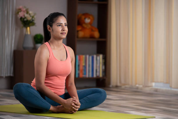 bella giovane donna attraente che fa yoga stretching esercizio a casa, concetto di salute, concetto di fitness, - baddha konasana foto e immagini stock