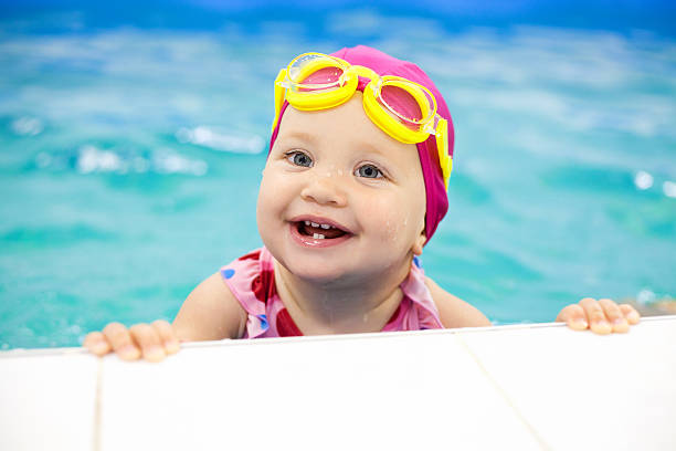 beautiful baby in her swim class smiling - swimming baby stockfoto's en -beelden