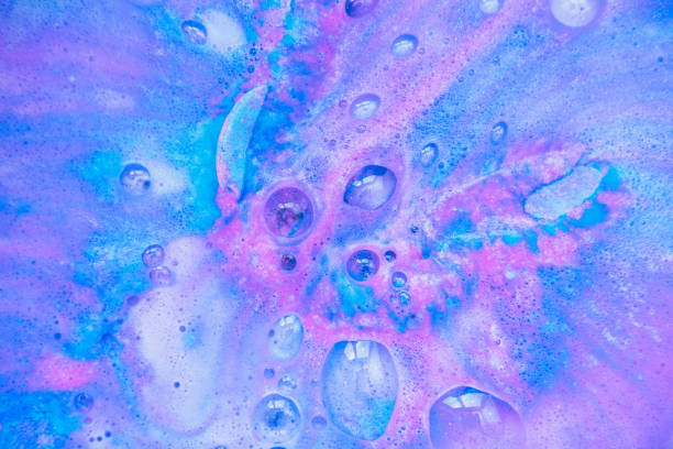 Beautiful bath bomb dissolves in blue and pink colors in the water. stock photo
