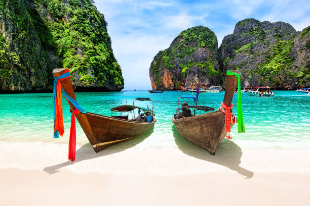 beautiful beach with thai traditional wooden longtail boat and blue sky in maya bay, thailand. - maya bay imagens e fotografias de stock