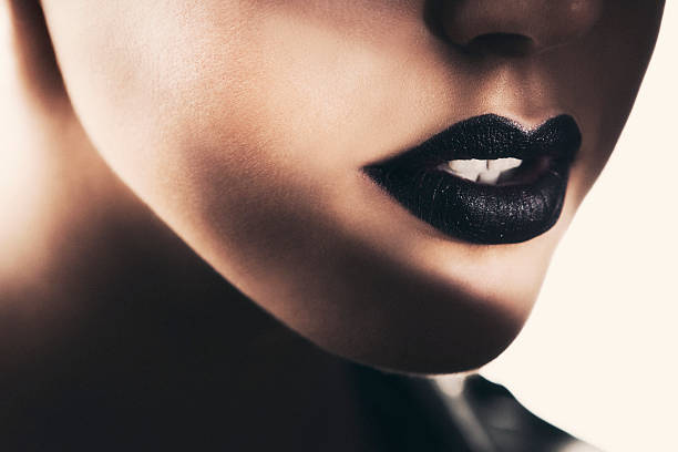 Beautiful black lips Close-up of beautiful black lips, illuminated with a selective spotlight. chiaroscuro stock pictures, royalty-free photos & images