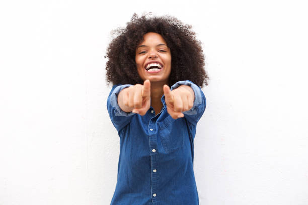 Beautiful black woman pointing fingers and laughing Portrait of beautiful black woman pointing fingers and laughing pointing stock pictures, royalty-free photos & images