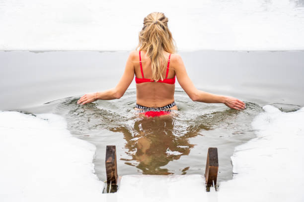 vacker blond hår flicka med röd baddräkt bad och simning i det kalla vattnet - ice bath in natural frozen lake bildbanksfoton och bilder