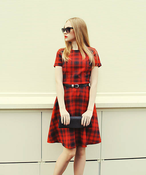 Beautiful blonde woman in red dress, sunglasses with handbag clu stock photo