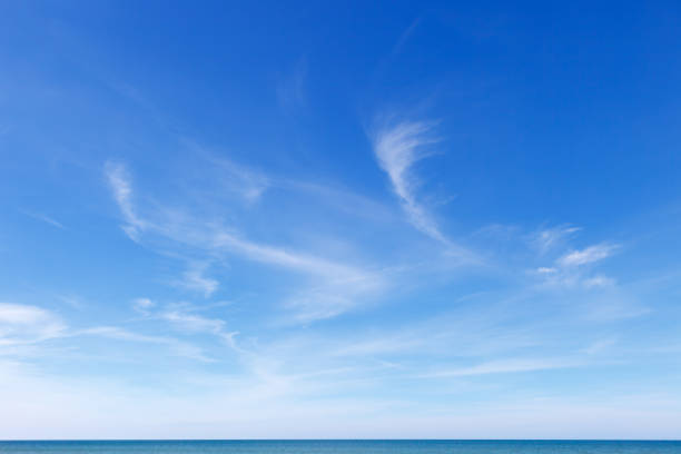 beautiful blue sky over the sea with translucent, white, cirrus clouds - fino imagens e fotografias de stock