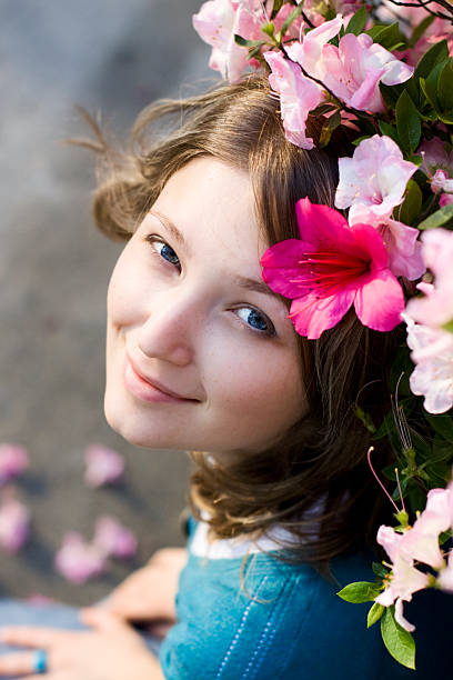 Beautiful blue-eyed girl under the flowered tree stock photo