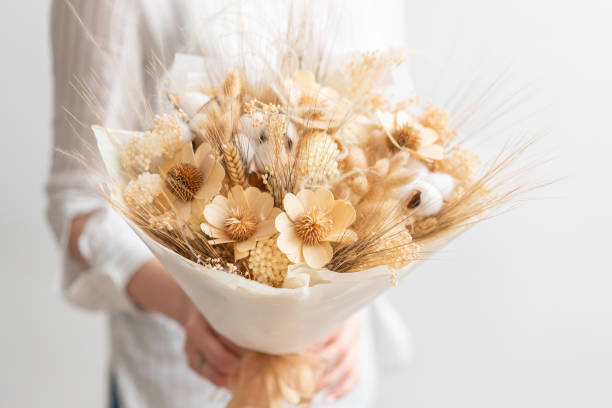 beautiful bouquet of mixed dried flowers in woman hand. the work of the florist at a flower shop. Delicate Pastel tones color stock photo