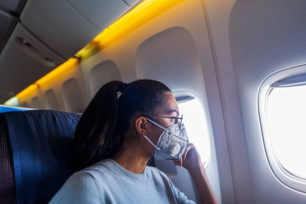 Beautiful business woman in a plane Young woman looking outside the window plane window seat stock pictures, royalty-free photos & images