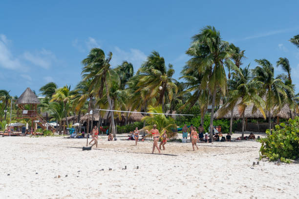 Beautiful Caribbean beach Playa Norte or North beach on the Isla Mujeres near Cancun with people playing volleyball, Mexico stock photo